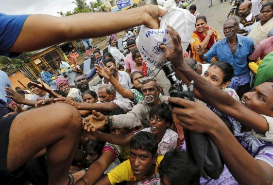 Flood-affected people raise their hands to receive free food being distributed by Indian Navy personnel in Chennai, India, December 5, 2015. REUTERS/Anindito Mukherjee