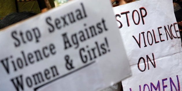 A demonstrator holds placards during a protest in New Delhi December 29, 2012.