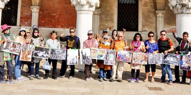 Indonesian tourists hold up photographs of Kolkata in Rome as part of The Sainthood Project.