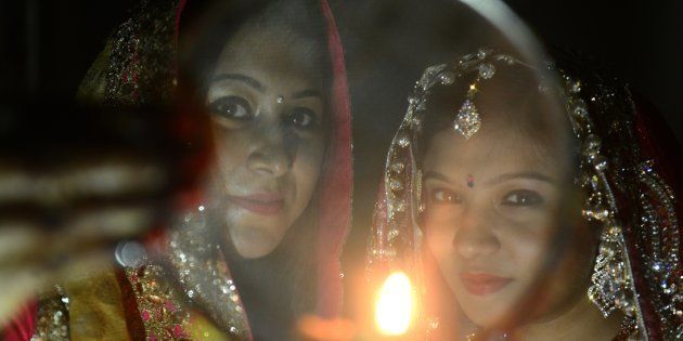 Indian Hindu married women perform a ritual on the occasion of the Hindu festival of Karva Chauth (Husband's Day) in Siliguri on October 30, 2015.