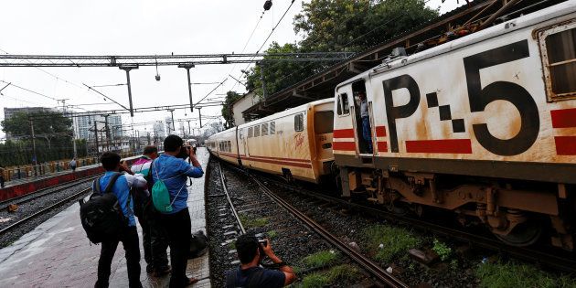 Photographers take pictures of the Talgo train as it arrives at a railway station in Mumbai.