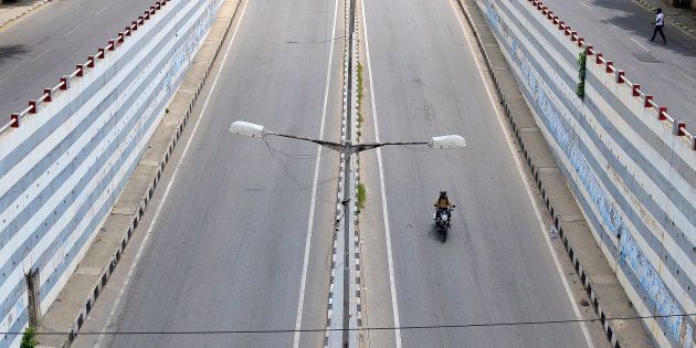 A motorist rides a bike on an empty road on the day of a state-wide strike called by various organisations to protest against a Supreme Court order asking the southern state of Karnataka to release water from the river Cauvery to the neighbouring state of Tamil Nadu, in Bengaluru, India, September 9, 2016.