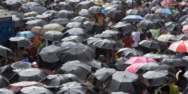 People sheltering under umbrellas during rain, Mumbai, Maharashtra, India