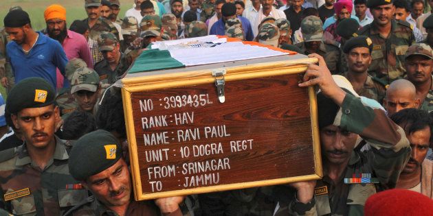 Soldiers carry a coffin containing the body of their fallen colleague Ravi Paul, killed in Sunday's attack at an Indian army base in Kashmir's Uri.