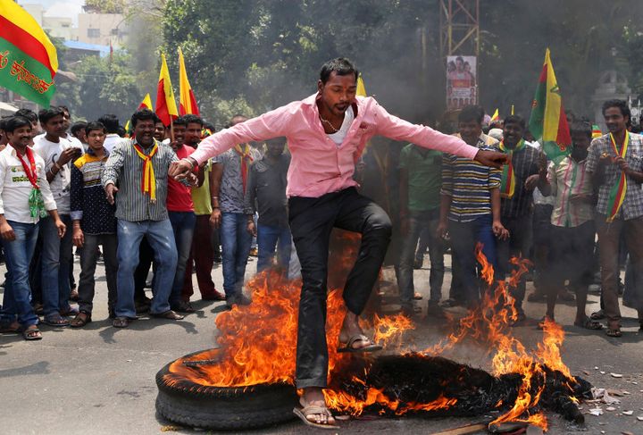 An activist jumps over a burning effigy of Tamil Nadu CM Jayalalitha during a protest against a recent Supreme Court order on Cauvery water sharing dispute.