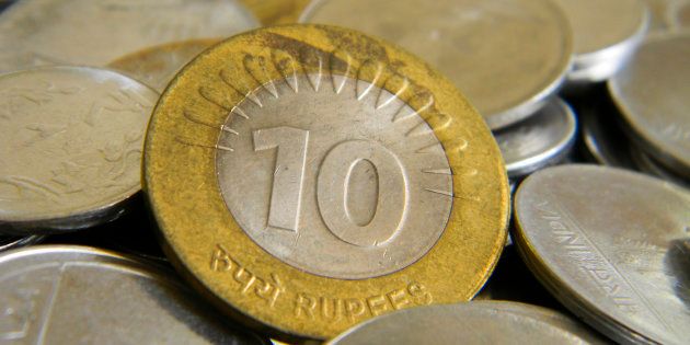 Ten rupee coin of Indian currency lying on top of other coins.