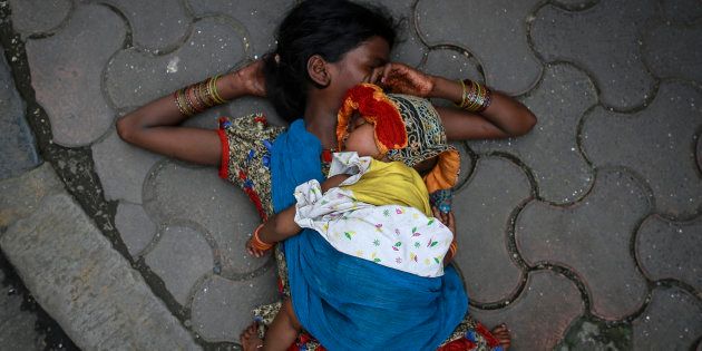 (Representational image) File photo of a woman sleeping with her baby on sidewalk.