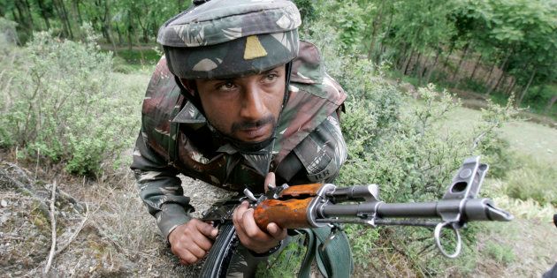 FILE PHOTO: An Indian army soldier takes up position during a search operation in Baramulla, about 55 km (34 miles) north of Srinagar, June 2, 2007.