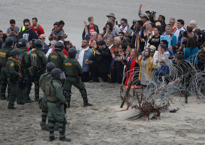 Police and U.S. Border Patrol agents face members of an interfaith group showing support for Central American asylum-seekers and calling for an end to detaining and deporting immigrants on Dec. 10, 2018.