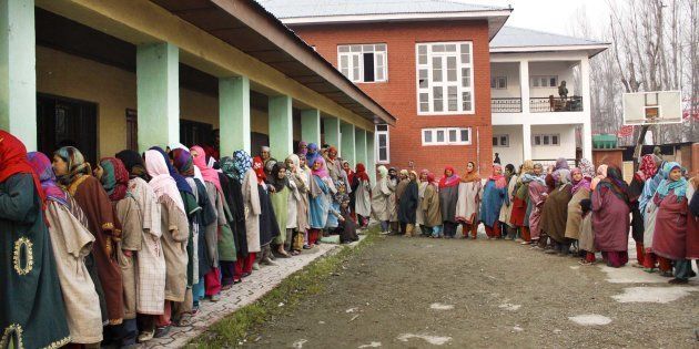 Kashmiri women stand in a queue to cast their votes.