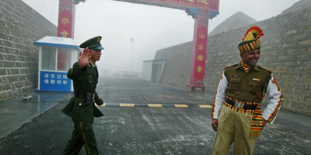 In this photograph taken on July 10, 2008 a Chinese soldier (L) and an Indian soldier stand guard at the Chinese side of the ancient Nathu La border crossing between India and China.