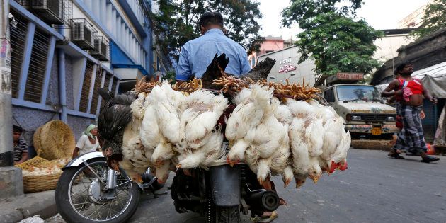 A man transports chickens on his motorbike at a roadside poultry market in Kolkata, India, May 4, 2016. REUTERS/Rupak De Chowdhuri