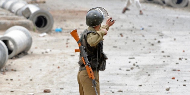 An Indian paramilitary policeman aims his slingshot towards a Kashmiri demonstrator during an anti-election protest in downtown Srinagar.