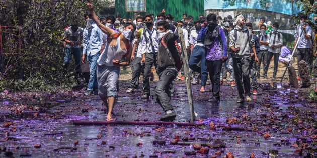 Kashmiri students throw stones at government forces, after they tried to march in the city's main commercial hub, to protest the attack by government forces on students on April 17, 2017 in Srinagar.