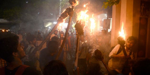 Activists participate in a torch rally against the communal violence in Bengal.
