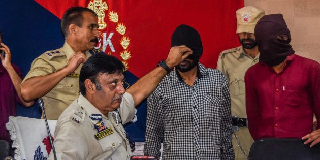 Muneer Ahmed Khan, Inspector General of police Kashmir, shows Sandeep Kumar, a Hindu non-local, militant during a press conference at a police head quarter on July 10, 2017 in Srinagar.
