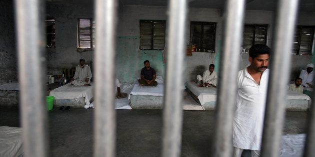 File photo of inmates resting behind bars in a barrack at Kotbhalwal central jail in Jammu May 18, 2011.