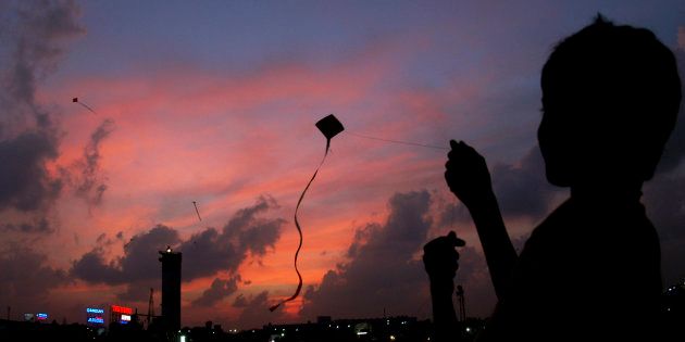A boy flies a kite in the evening in Chennai February 2, 2007. REUTERS/Babu (INDIA)