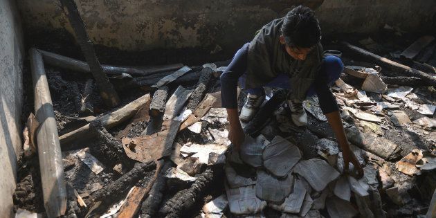 A Kashmiri student looks at damaged property at a partially burnt government high school in Goripora, on the outskirts of Srinagar.
