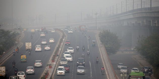 Traffic drives through smog in Delhi.
