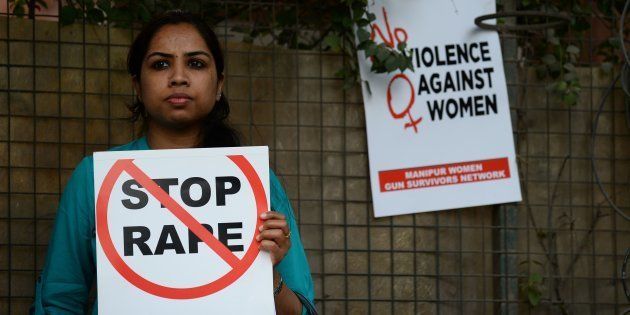 An Indian social activist holds a placard during a protest against a rape at Hauz Khas village in New Delhi.