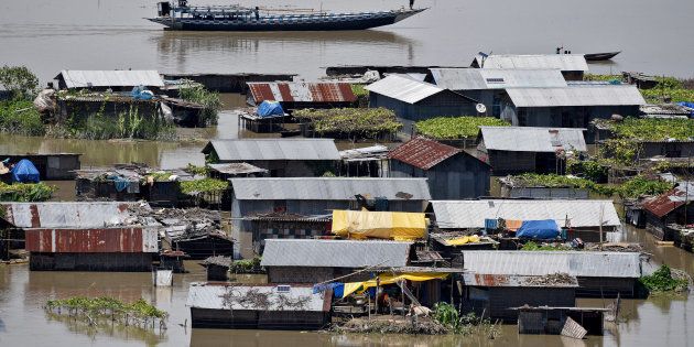 Villagers use a boat as they row past partially submerged houses at a flood-affected village in Morigaon district in the northeastern state of Assam, India July 14, 2017.