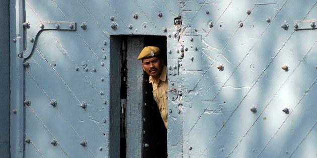 A policeman peers from inside the gate of Chanchalguda jail in Hyderabad.