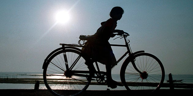 Girl riding bicycle, Delhi, India. (Photo by: IndiaPictures/UIG via Getty Images)