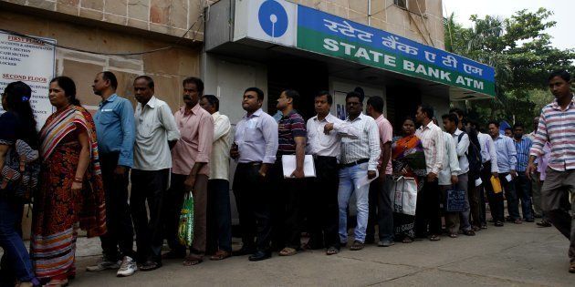 People stand in the queue to enter into the bank to withdraw money and exchange the discontinued notes.