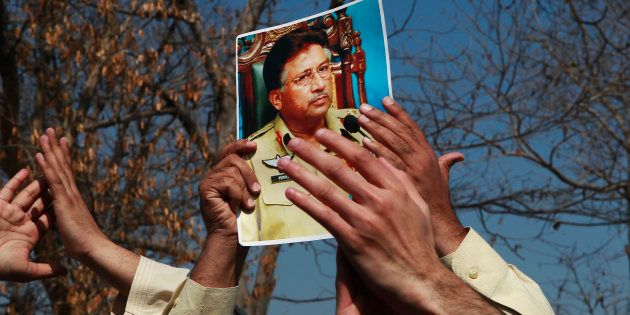 A supporter holds a picture of former Pakistani President Pervez Musharraf, during a protest with others at the Special Court where Musharraf will attend his trial in Islamabad February 18, 2014.