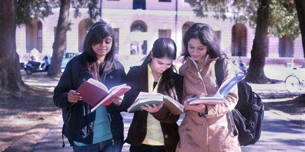 REPRESENTATIVE IMAGE of three college students discussing their notes after exams.