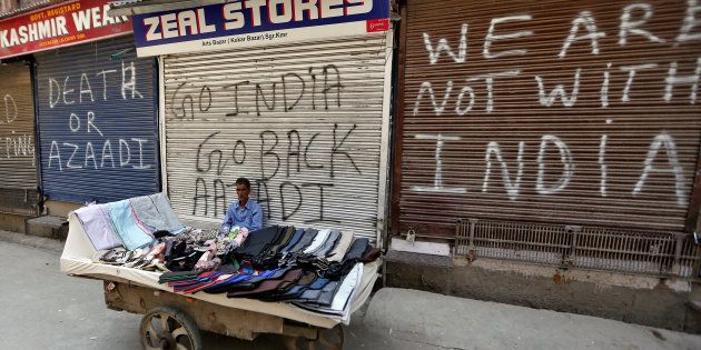 A vendor sits in front of closed shops during a strike called by Kashmiri separatists to protest the arrest of its members in Srinagar July 25, 2017. REUTERS/Danish Ismail