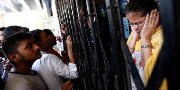 A bank employee reacts as people shout while they wait to enter a bank in Mumbai.