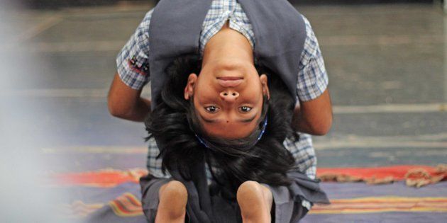 A child performs Yoga on International Yoga Day at The National Sports Club of India (NSCI) in Mumbai,