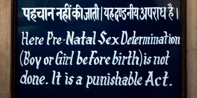 A sign stating 'Here Pre-Natal Sex Determination ( Boy or Girl before birth) is not done. It is a punishable act.' hangs outside a clinic that uses ultrasound, in Rohtak, Haryana, in India.