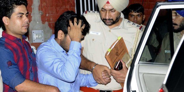 Vikas Barala (in blue shirt) being taken into Chandigarh police custody at Sector 26 Police Station.