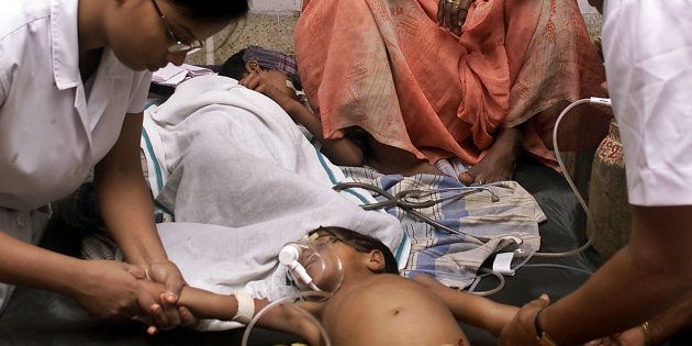 Indian nurses attend to a child who is suffering from encephalitis at a hospital in Gorakhpur.