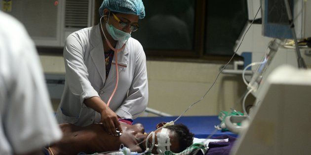 Indian medical staff attend to a child admitted in the Encephalitis ward at The Baba Raghav Das Hospital in Gorakhpur.
