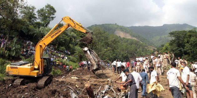 Heavy machinery removes debris as rescue personnel search for survivors and bodies of victims after a landslide along a highway at Kotrupi, some 200 kilometres (124 miles) from Himachal Pradesh state capital Shimla.