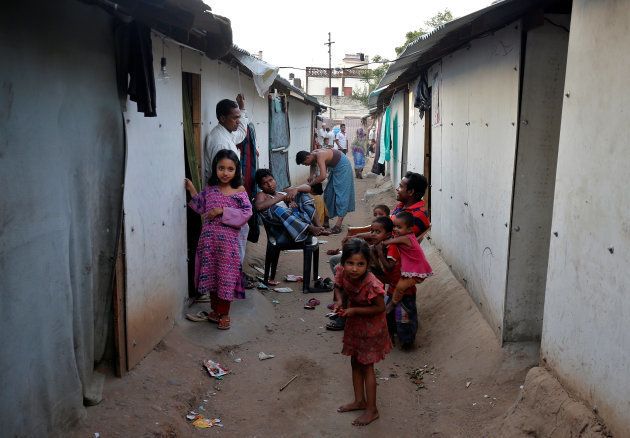 People belonging to Rohingya Muslim community sit outside their makeshift houses on the outskirts of Jammu.