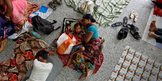 People rest on the floor outside the intensive care unit (ICU) of the Baba Raghav Das hospital in the Gorakhpur district, August 14, 2017.