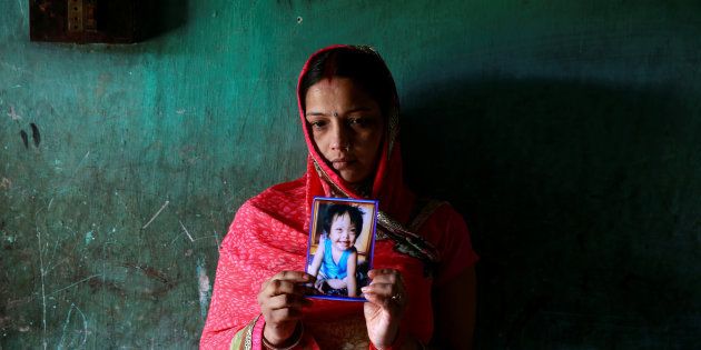 Rinki Singh, 31, holds a photo of her daughter Aarushi, 6, who died in the intensive care unit (ICU) of the Baba Raghav Das hospital in the Gorakhpur district, August 14, 2017.