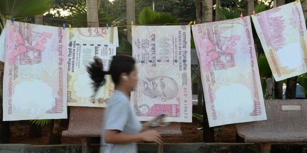A jogger passes replica prints of the demonetised ₹500 and ₹1,000 notes as part of a street art exhibition in Mumbai. on November 20, 2016.