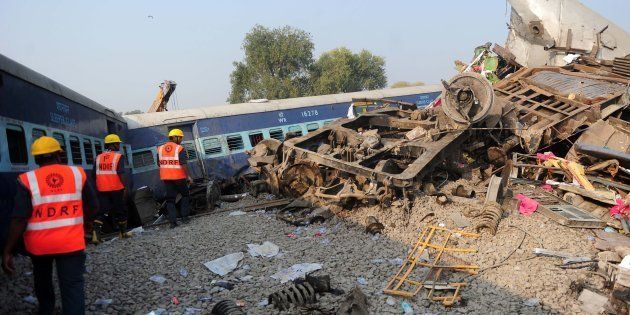 Indian rescue workers search for survivors in the wreckage of a train that derailed near Pukhrayan.