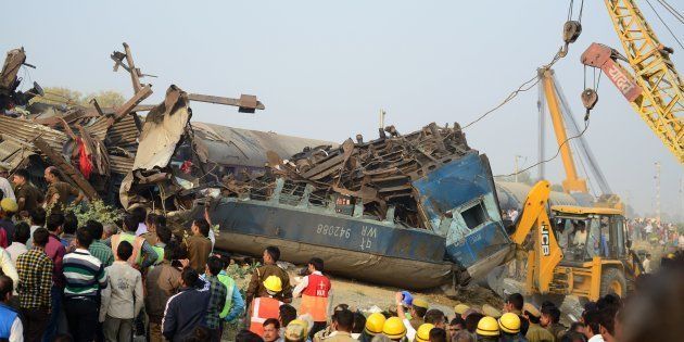 Rescue workers search for survivors in the wreckage of a train that derailed near Pukhrayan in Kanpur district on Sunday.