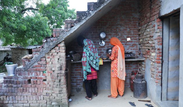 Manvi's mother (R) makes tea at their home in Dhanauri Mafi village in UP.