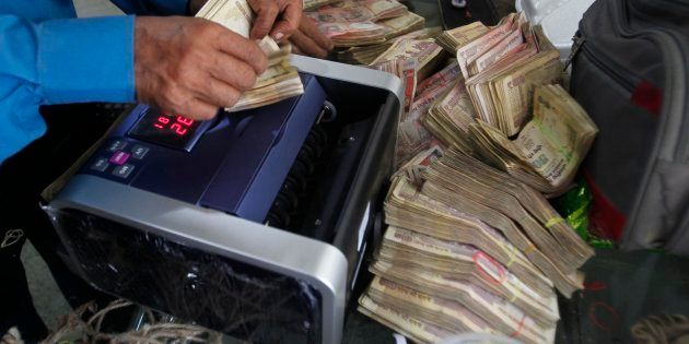 Bank employees count notes deposited by people after demonetisation.