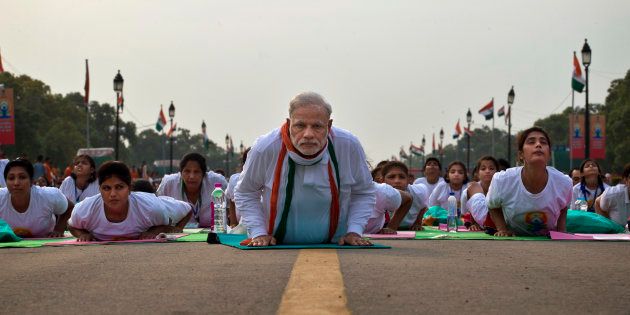 Indian Prime Minister Narednra Modi lies down on a mat as he performs yoga along with thousands of Indians on Rajpath, in New Delhi, India, Sunday, June 21, 2015. Millions of yoga enthusiasts are bending their bodies in complex postures across India as they take part in a mass yoga program to mark the first International Yoga Day.(AP Photo/Saurabh Das)