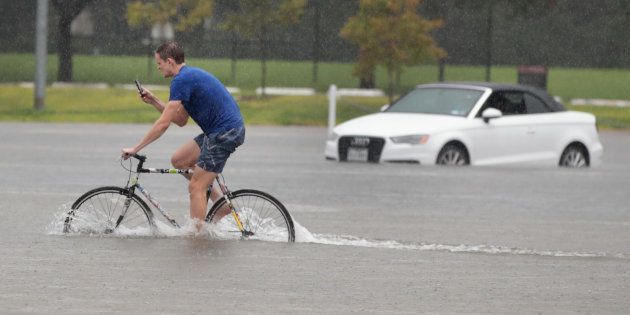 HOUSTON, TX - AUGUST 27: Cade Ritter rides through a flooded parking lot on the campus of Rice University afer it was inundated with water from Hurricane Harvey on August 27, 2017 in Houston, Texas. Harvey, which made landfall north of Corpus Christi late Friday evening, is expected to dump upwards to 40 inches of rain in areas of Texas over the next couple of days. (Photo by Scott Olson/Getty Images)