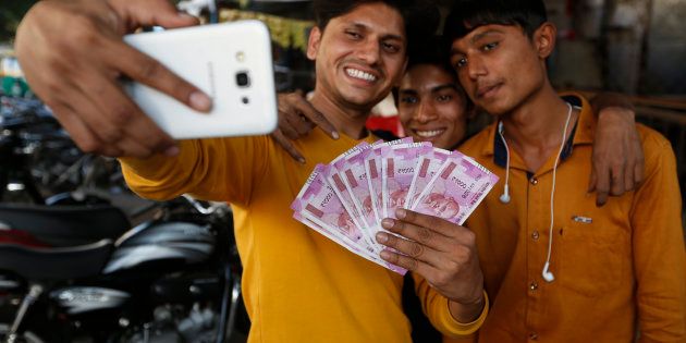 Indians takes selfie with new currency notes of 2000 Indian rupee in Ahmadabad, India, Friday, Nov. 11, 2016. (AP Photo/Ajit Solanki)
